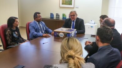 O presidente do Tribunal Regional Eleitoral do Rio Grande do Norte (TRE-RN), desembargador Cornélio Alves, esteve reunido com a juíza Ticiana Nobre, diretora da Escola Judiciária Eleitoral/RN, e representantes da Câmara Municipal e do Poder Executivo do município de Grossos, na tarde desta segunda-feira (4), para assinatura de acordo de cooperação. O documento apresenta as tratativas para realização da primeira eleição do projeto Câmara Mirim na cidade. Para essa primeira edição do projeto no município, jovens do 6º ao 8º ano de três escolas públicas, com idade de 10 a 15 anos, irão participar como candidatos ao cargo de jovem parlamentar e também como votantes. A eleição será realizada no dia 20 de setembro, com urnas eletrônicas preparadas e cedidas pelo TRE-RN. Serão eleitos 18 candidatos, sendo nove titulares e nove suplentes, que serão capacitados antes de assumirem os cargos. Eles cumprirão mandato durante um ano e terão sessões plenárias quinzenais para debater, elaborar e aprovar projetos de lei. A parceria pretende fortalecer o engajamento dos jovens na política e conscientizar sobre a importância de eleições justas e democráticas. De acordo com o presidente da Câmara Municipal de Grossos, vereador Dauster Rernard, os jovens da cidade se encontram desinteressados com a política, por isso a importância da realização desse projeto, que foi abraçado pelos gestores locais. “Nada melhor do que começar por essa faixa etária que muitas vezes vemos um desinteresse pela política. Então ele irá contribuir na criação de uma juventude mais engajada politicamente”, destacou o vereador. O papel da EJE/TRE-RN vai além das urnas. A equipe realiza palestras nas escolas participantes com temáticas a respeito do voto democrático. Durante a reunião, a juíza Ticiana falou da importância dessa ação e dos seus frutos. “Agradeço a confiança em nosso trabalho. É um projeto que nos orgulha porque a EJE tem a função primordial de difundir a cidadania, os preceitos do cidadão e a questão da democracia nas escolas para o público jovem, pessoas que inclusive estão próximas a se alistar”, disse a juíza. Além do desembargador Cornélio e a juíza Ticiana, estiveram presentes o presidente da Câmara Municipal de Grossos, vereador Dauster Rernard; o vice-prefeito da cidade, Galego Caetano; Alexandre Santos, vice-presidente da Câmara; o vereador João Carlos; a vereadora Dorinha do Córrego; Cintia Seabra, também vereadora; Joyle Fernandes, contadora da Câmara e Louise Vitória.